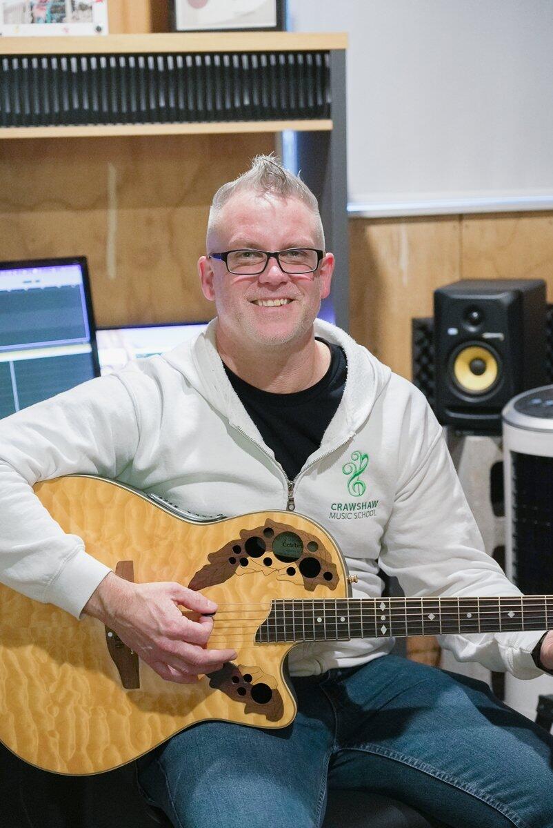 AJ Crawshaw with an acoustic guitar